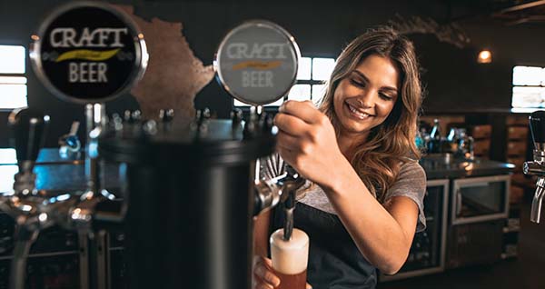 young woman pouring beer into the glass.